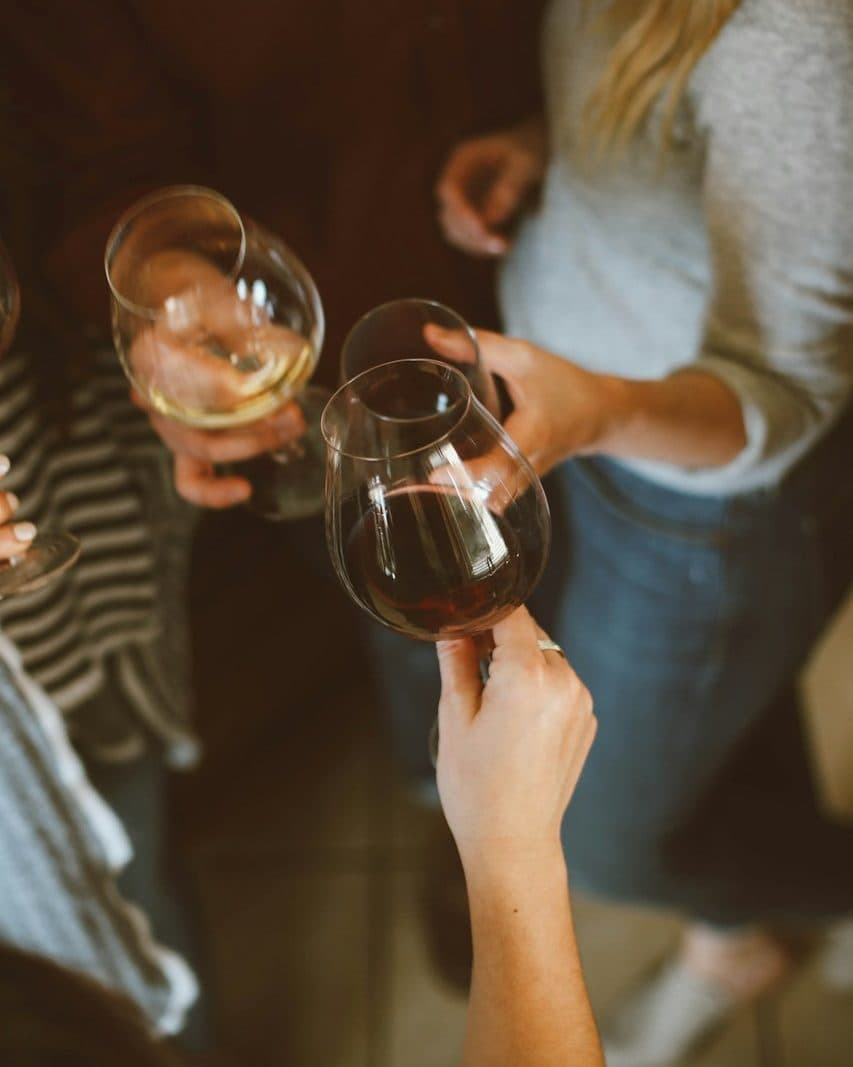 Friends raising wine glasses together around a table