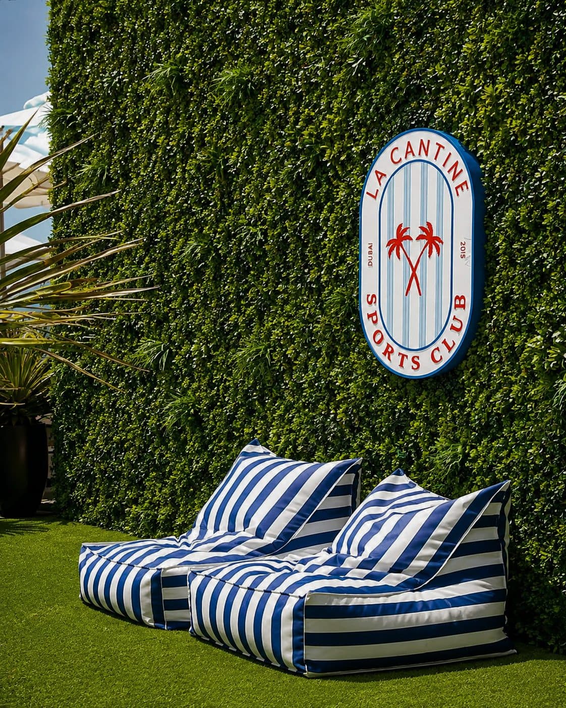 Striped loungers against a green hedge at the club